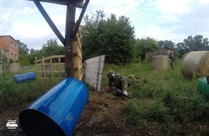 Gracz paintballowy osłonięty za przeszkodą