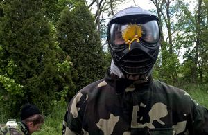 Uczestnik w masce ochronnej po trafieniu kulką z farbą