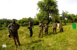 Drużyna paintballowa na zielonym poligonie